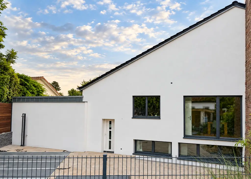 Modernes-Haus-mit-Terrasse-und-Garten Modernes Einfamilienhaus mit weißer Fassade, großen Fenstern, Terrasse und Garten